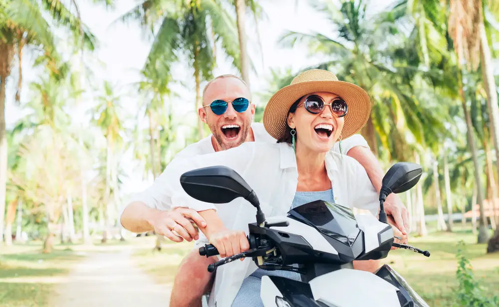 couple in white riding a motorcycle