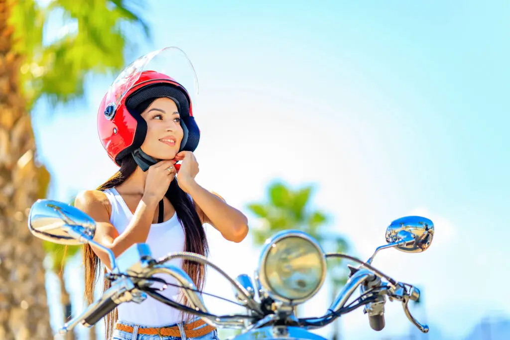 woman in a red helmet riding a motorcycle